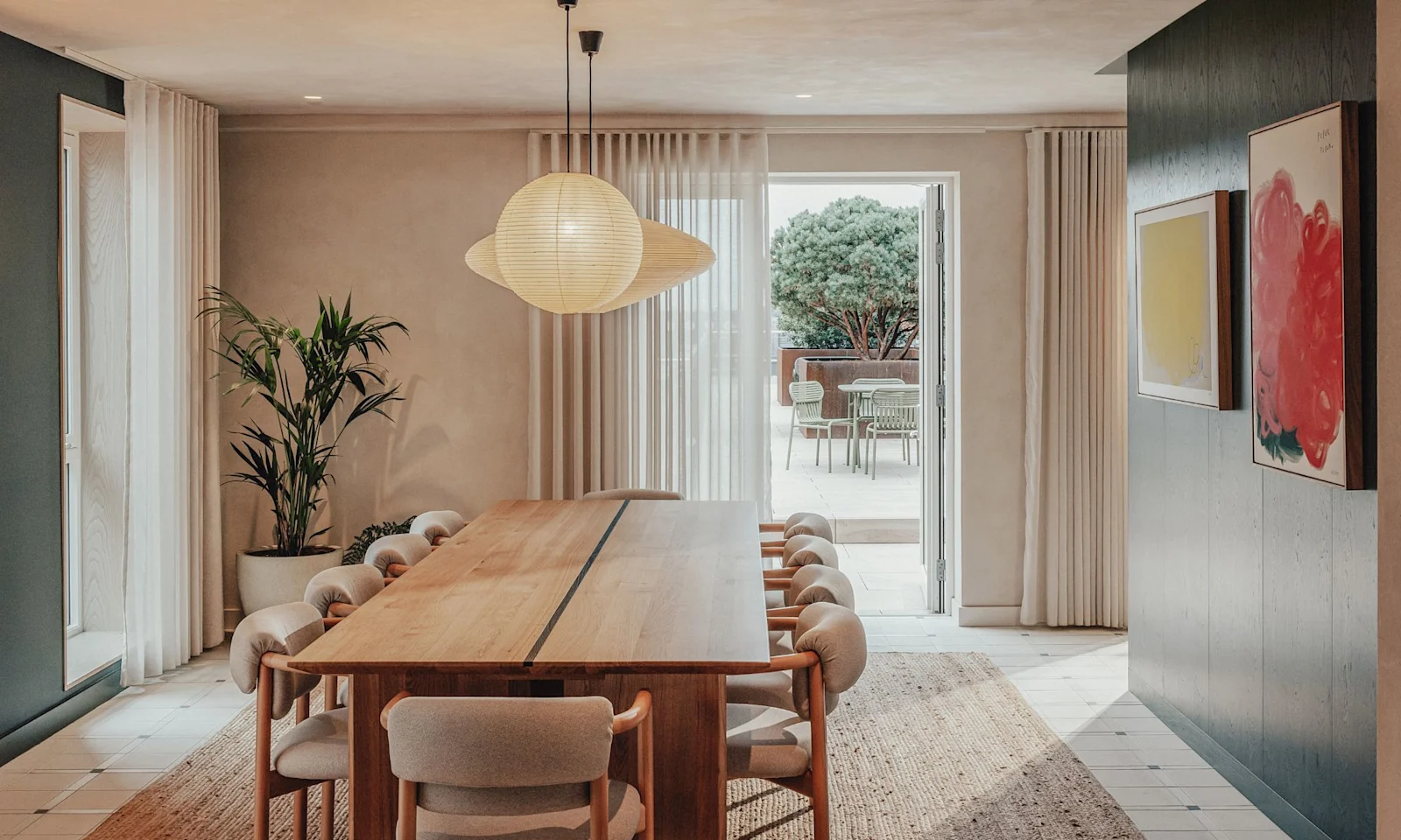 A dining room with a long wooden table and chairs