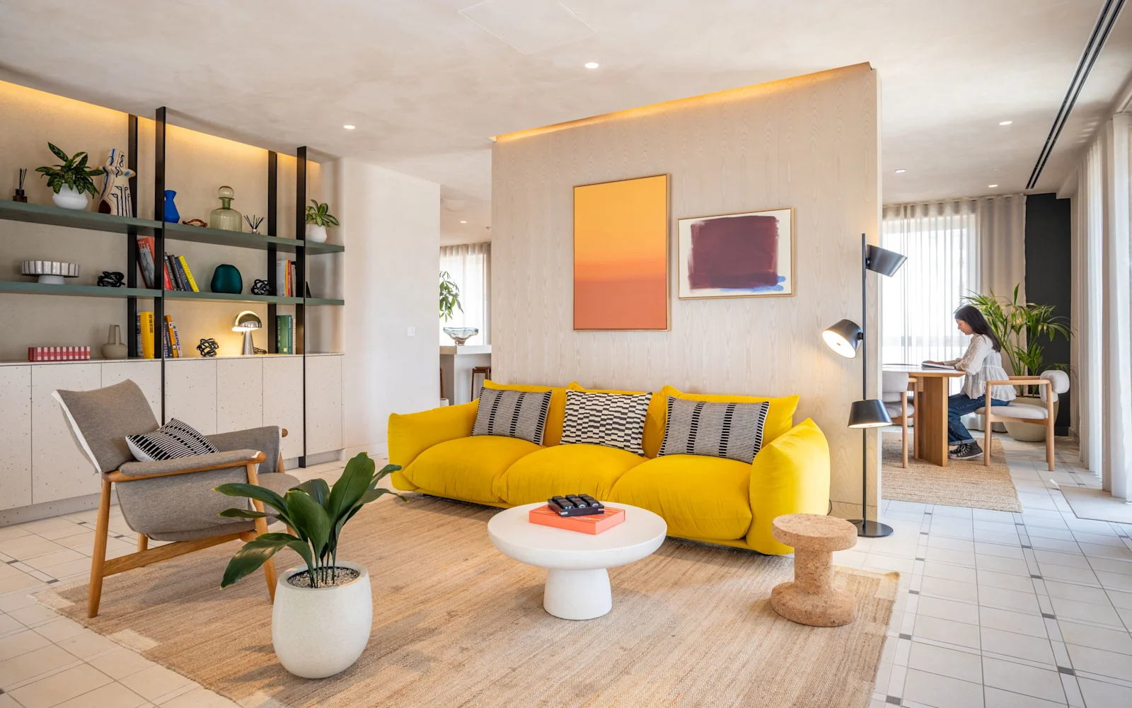 A resident lounge with a yellow sofa and a painting on the wall