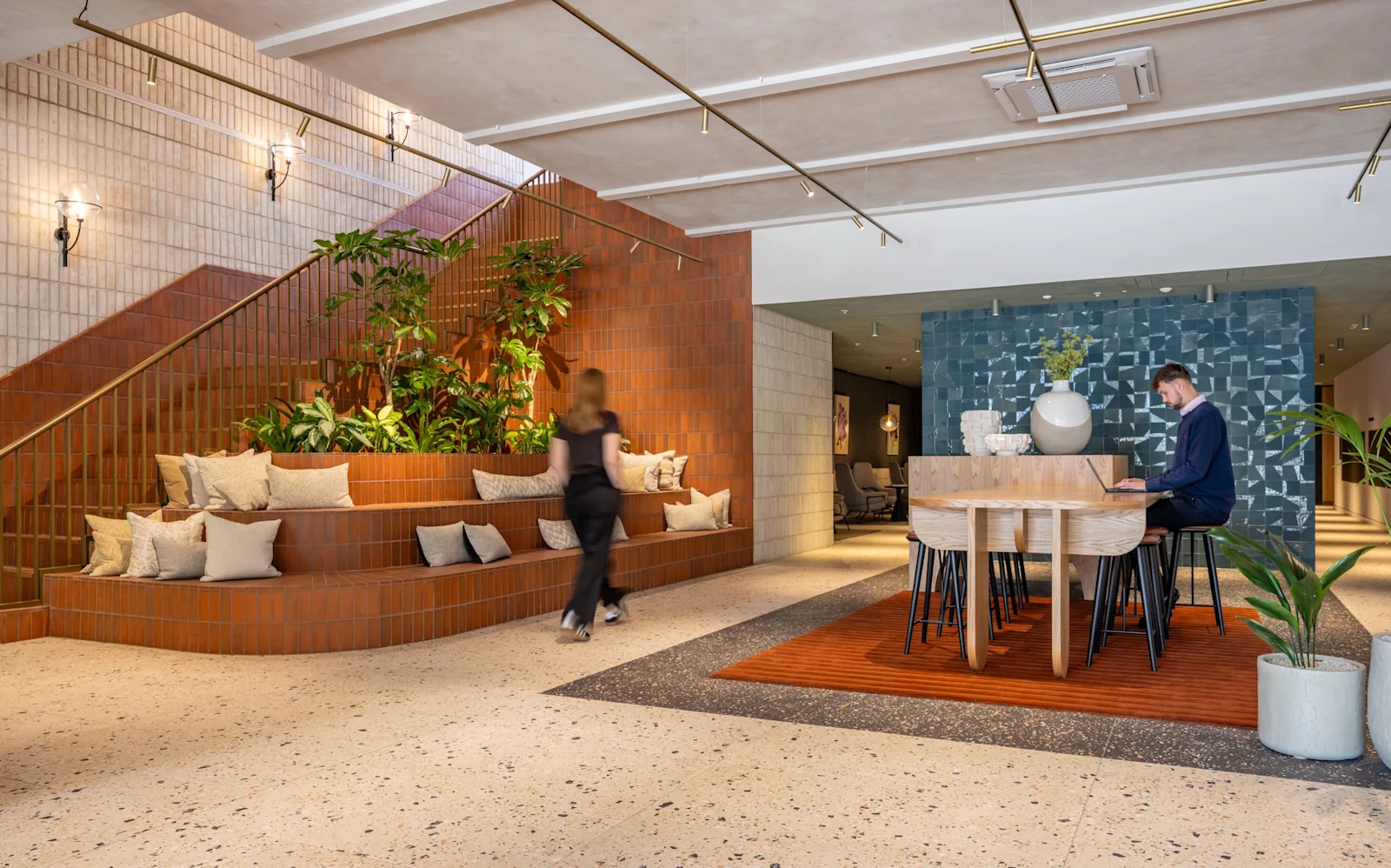 The lobby, with a curved planter and people working at a table