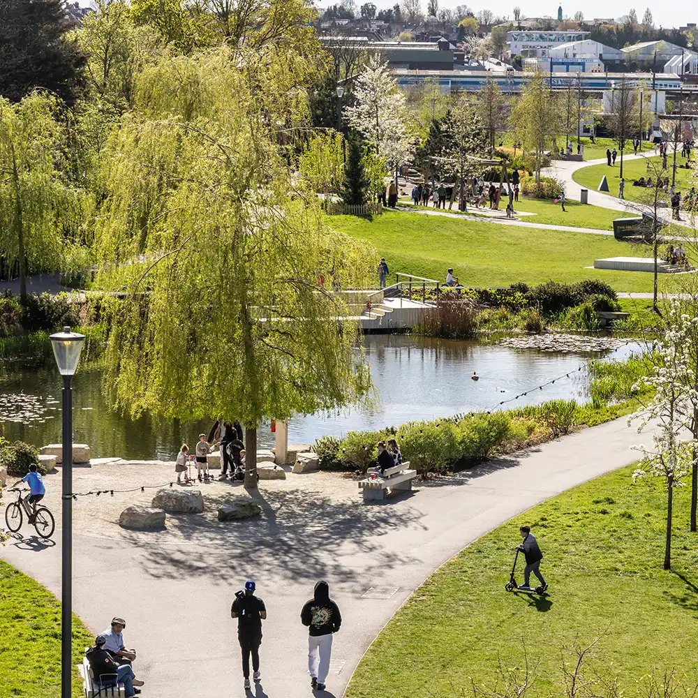 People walking and cycling beside the water in Claremont Park